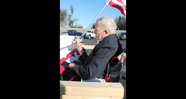 F.W. Webb owner John Pope signs the final beam before it is raised into position for the company's new Londonderry, NH distribution center.