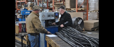 JGB employees Ira Bird and Phil Spencer feed a hose through a crimping machine. (JGB photo)