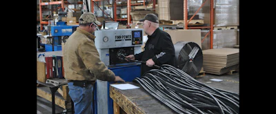 JGB employees Ira Bird and Phil Spencer feed a hose through a crimping machine. (JGB photo)