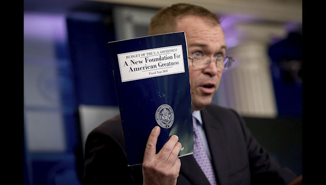 Budget Director Mick Mulvaney holds up a copy of President Donald Trump's proposed fiscal 2018 federal budget as he speaks to members of the media in the Press Briefing Room of the White House in Washington, Tuesday, May 23, 2017. (AP Photo/Andrew Harnik)