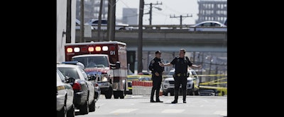 A San Francisco police officer gestures while standing outside a UPS package delivery warehouse where a shooting took place Wednesday in San Francisco. (AP Photo/Eric Risberg)