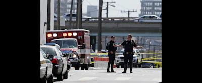 A San Francisco police officer gestures while standing outside a UPS package delivery warehouse where a shooting took place Wednesday in San Francisco. (AP Photo/Eric Risberg)