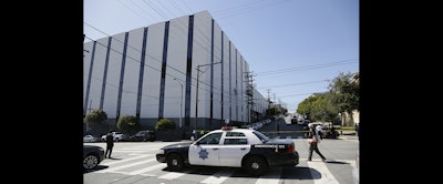 A San Francisco police car blocks a roadway outside a UPS package delivery warehouse where a shooting took place Wednesday in San Francisco. (AP Photo/Eric Risberg)