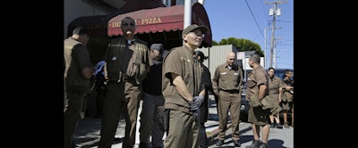 UPS workers gather outside a UPS package delivery warehouse where a shooting took place Wednesday in San Francisco. (AP Photo/Eric Risberg)