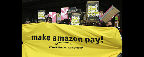Demonstrators hold a banner and posters during a rally against the online retailer Amazon in Berlin, Germany on Friday, Nov. 24. (Maurizio Gambarini/dpa via AP)
