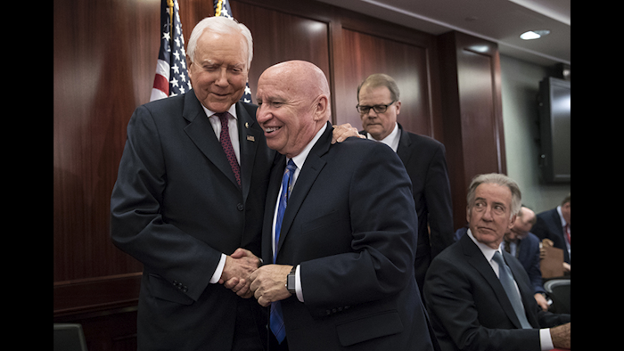 House Ways and Means Committee Chairman Kevin Brady, center, embraces Senate Finance Committee Chairman Orrin Hatch after GOP leaders announced they have forged an agreement on a sweeping overhaul of U.S. tax laws Wednesday in Washington D.C. (AP photo)
