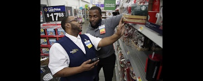 In this photo from Nov. 9, 2017, Walmart employee Kenneth White, left, is coached by Shabazz Bonner while using an inventory app during a class at the Walmart Academy at the store in North Bergen, N.J. (AP photo)