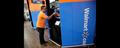 In this photo from Nov. 9, 2017, Setal Gandhi, a department manager at a Walmart store in Secaucus, N.J., demonstrates how shoppers can pick up online orders at a tower near the entrance of the store. (AP photo)