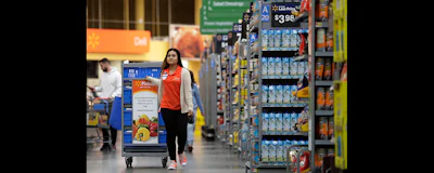In this photo from Nov. 9, 2017, Laila Ummelaila, a personal shopper at the Walmart store in Old Bridge, N.J., pulls a cart with bins as she shops for online shoppers. (AP photo)