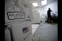 Steve Strong fills bottles of vodka at his S.D. Strong Distilling business in Parkville, Mo. Strong is planning to hire some part-time employees and buy some equipment as a result of the new tax law. (AP Photo)