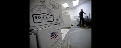 Steve Strong fills bottles of vodka at his S.D. Strong Distilling business in Parkville, Mo. Strong is planning to hire some part-time employees and buy some equipment as a result of the new tax law. (AP Photo)