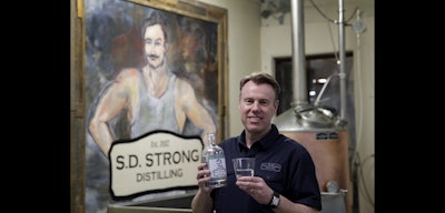 Steve Strong holds a bottle of gin at his S.D. Strong Distilling business in Parkville, Mo. (AP Photo)