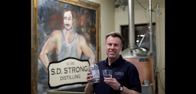 Steve Strong holds a bottle of gin at his S.D. Strong Distilling business in Parkville, Mo. (AP Photo)