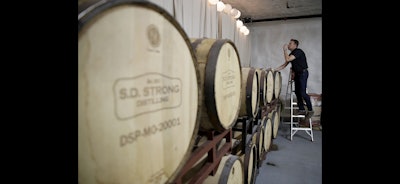 Steve Strong checks a batch of aging whiskey at his S.D. Strong Distilling business in Parkville, Mo. (AP Photo)