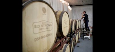 Steve Strong checks a batch of aging whiskey at his S.D. Strong Distilling business in Parkville, Mo. (AP Photo)