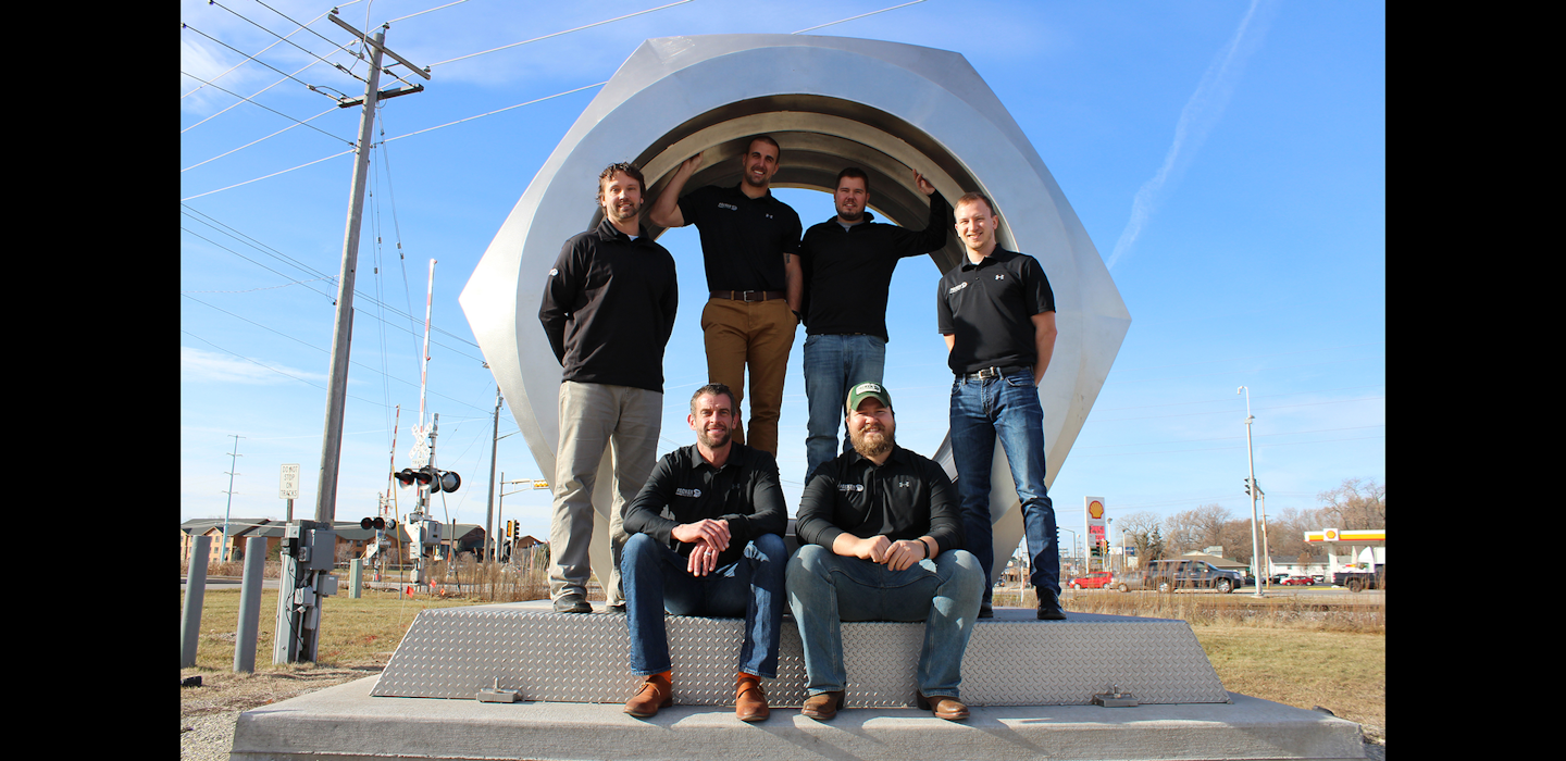Packer Fastener's management team poses with the company's 10-foot, 3.5-ton Hex Nut outside its Green Bay, WI headquarters.