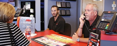 Greg Goodman, right, assists a customer on the phone while son Chandler Goodman, center, helps a customer at the counter, in their Alta Mere franchise in Oklahoma City. (AP)