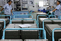 In this July 27, 2018, photo, workers transfer Lithium-ion batteries in a factory in Taizhou in east China's Jiangsu province. Chinatopix via AP)