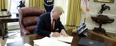 In this Dec. 22, 2017 photo, President Donald Trump signs into law a $1.5 trillion tax overhaul package in the Oval Office of the White House. (AP)