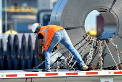 In this July 25 photo, a truck driver chains down a roll of steel to his flatbed at the NUCOR Steel Gallatin plant in Ghent, KY. The rolls, weighing as much as 20 tons, are transported one at a time. (AP)