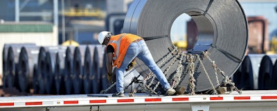In this July 25 photo, a truck driver chains down a roll of steel to his flatbed at the NUCOR Steel Gallatin plant in Ghent, KY. The rolls, weighing as much as 20 tons, are transported one at a time. (AP)