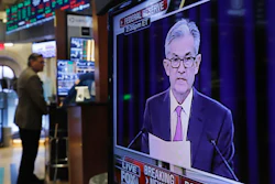 In this June 19, 2019 file photo, the Washington news conference of Federal Reserve Chair Jerome Powell appears on television screen on the trading floor of the New York Stock Exchange shows the rate decision of the Federal Reserve.