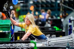 In this June 12, 2019 file photo, General Motors employees work on the chassis line as they build the frame, power train and suspension onto the truck's body at the Flint Assembly Plant in Flint, MI.