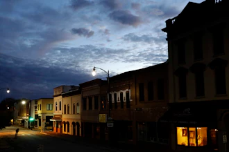 In this Oct. 28, 2017 file photo, the storefront window of a portrait studio is lit up along a downtown street at dusk in Lumberton, N.C. With a little over one month to go in 2019, small business owners should think about purchases or investments that make good business sense and will give them a break on their taxes.