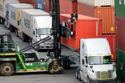 In this Oct. 2, 2019 file photo, a shipping container is lifted off the back of a truck as others wait in line to have their cargo unloaded at a terminal on Harbor Island in Seattle.