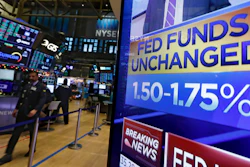 A television screen on the floor of the New York Stock Exchange shows the rate decision of the Federal Reserve on Wednesday, Dec. 11.