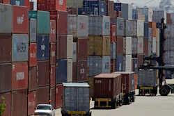 In this July 22, 2019 file photo, stacked containers wait to be loaded on to trucks at the Port of Oakland in Oakland, CA. China's government says trade negotiators are in “close communication” with Washington ahead of a weekend deadline for a U.S. tariff hike.