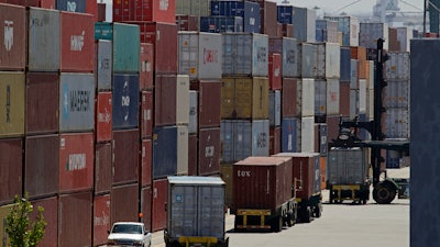 In this July 22, 2019 file photo, stacked containers wait to be loaded on to trucks at the Port of Oakland in Oakland, CA. China's government says trade negotiators are in “close communication” with Washington ahead of a weekend deadline for a U.S. tariff hike.