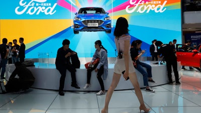 In this April 25, 2018 file photo, attendees visit the Ford booth during Auto China 2018 show held in Beijing, China.