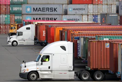 In this Oct. 2, 2019 file photo, trucks are positioned to haul shipping containers at a terminal where containers are stacked five-high on Harbor Island in Seattle.