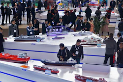 In this Dec. 3, 2019 photo, visitors look at the ship models exhibited by the China State Shipbuilding Corporation (CSSC) during the Marintec China exhibition in Shanghai, China.