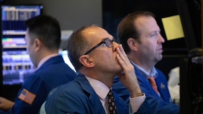 In this Jan. 2, 2020 file photo, traders monitor stock prices at the New York Stock Exchange.