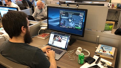 In this undated image provided by Cameron MacMillan, Jordan Davis, foreground, and Jason Wilson and Chad Wright, background work at the Better Collective Tennessee, RotoGrinders.com office in downtown Nashville. Sports can be a distraction at work the first few months of the year as pro football and college basketball hold their premier events. Business owners have to make a choice, whether, like McMillan at RotoGrinders.com, they'll allow or encourage staffers to enjoy the moment, or demand that everyone focus on work.