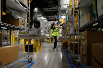 In this Dec. 17, 2019, file photo Jocelyn Nieto stows packages into special containers after Amazon robots deliver separated packages by zip code at an Amazon warehouse facility in Goodyear, AR.