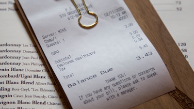 In this Feb. 11 photo, a line item shows an example of how the charge that Brent Frederick, founder of Jester Concepts, a restaurant group in Minneapolis uses as a 3% voluntary surcharge on guest checks to help pay for health insurance and mental health services and says almost all guests agree to pay it.