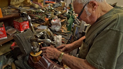 In this Jan. 29, 2020 file photo, Tony Bonczewski repairs a heel on a customer's shoe at his cobbler shop in Wilkes-Barre, PA. Small business owners have received some upbeat news on the economy this month. Retail sales figures released Friday showed that consumers were inspired by unseasonably warm weather to spend on their homes in January, but that overall sales growth was modest.