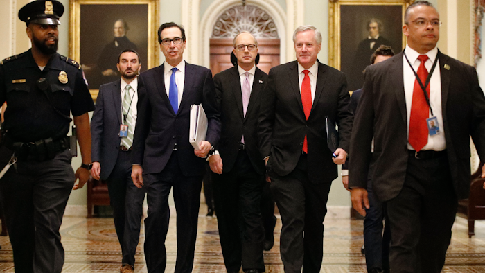 Treasury Secretary Steven Mnuchin, left, accompanied by White House Legislative Affairs Director Eric Ueland and acting White House chief of staff Mark Meadows, walks to the offices of Senate Majority Leader Mitch McConnell on Capitol Hill in Washington on Tuesday, March 24.