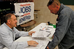 In this Nov. 2, 2017, photo, a recruiter in the shale gas industry, left, speaks with an attendee of a job fair in Cheswick, Pa.