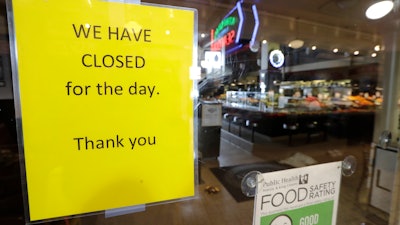 A sign advises of the closure of a restaurant at Pike Place Market on Tuesday, March 17 in Seattle.