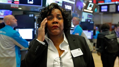 Yvette Arrington, with the New York Stock Exchange Trading Floor Operations, works on the floor of the NYSE, Monday, March 9, 2020. Stocks went into a steep slide Monday on Wall Street as coronavirus fears and a crash in oil prices spread alarm through the market, triggering the first automatic trading halt in over two decades.