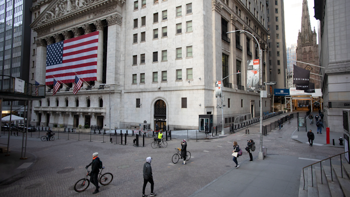 In this March 18 file photo, a few people walk on Wall Street in front of the New York Stock Exchange in New York. There are emerging signs that any recovery will fail to match the speed and severity of the economic collapse that occurred in just a few weeks.