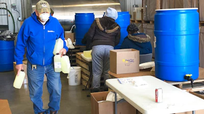 In this Thursday April 9 photo, employees at a new hand sanitizer factory work to load and manufacture product at the facility in Bismarck, ND. A number of North Dakota businesses have switched gears amid the coronavirus outbreak to make products in short supply.