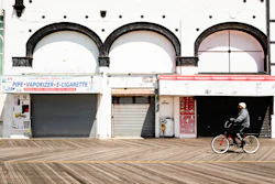 A cyclist rides past shuttered businesses during the coronavirus outbreak on the boardwalk in Atlantic City, N.J., Tuesday, April 28, 2020.