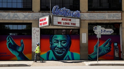 A worker passes a closed nightclub in Austin, Texas, May 18, 2020.