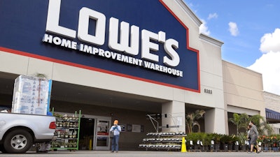 In this March 22 file photo, customers wearing masks walk into a Lowe's home improvement store in the Canoga Park section of Los Angeles. Lowe’s move to revamp its outdated online business in recent months paid off during the first quarter, as shut-in shoppers shifted to its online services for supplies for their do-it-yourself home projects during the pandemic.