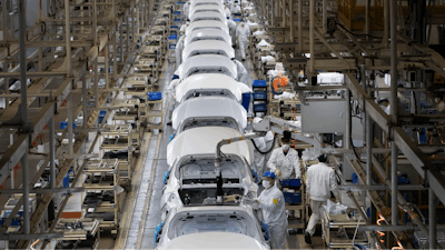 Employees work on a car assembly line.